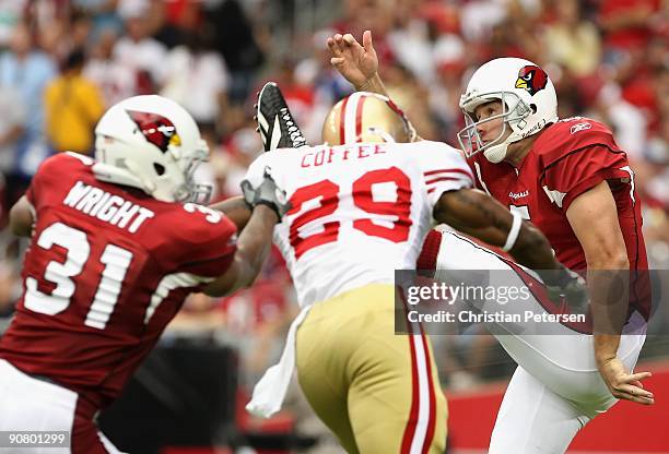 Punter Ben Graham of the Arizona Cardinals kicks the ball under pressure from Glen Coffee of the San Francisco 49ers during the NFL game at the...