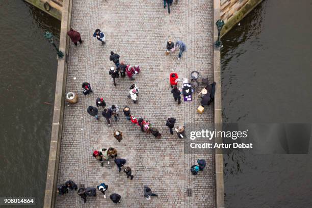 view of the city of prague taken for elevated perspective with bustle people walking in the charles bridge. - prague people stock pictures, royalty-free photos & images