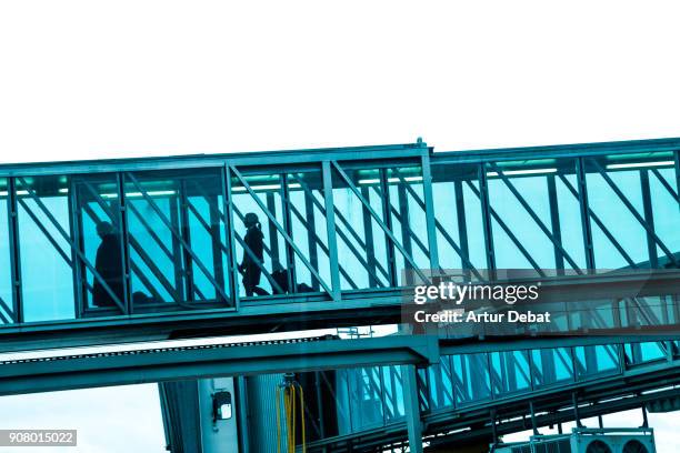 airport finger connecting with airplane with silhouettes of traveler people through the blue glass getting ready to boarding. - prague international airport stock pictures, royalty-free photos & images