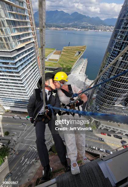 Rick Harker and Marlene Hoar kiss as they repel down the side of a skyscraper as part of their wedding ceremony September 15, 2009 in Vancouver,...