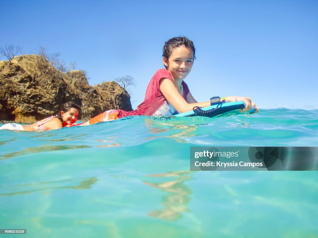 Teenage girls having fun on surfboard in the sea