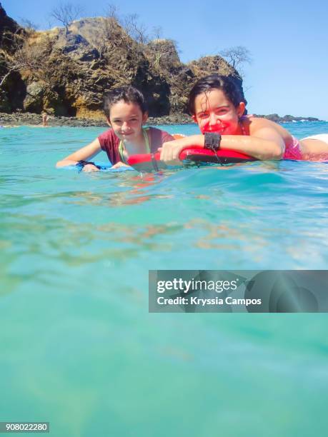 teenage girls having fun on surfboard in the sea - lanzarote stockfoto's en -beelden