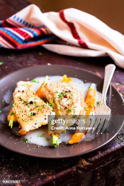 roasted white fish fillet with cream sauce and baby carrots on a plate, selective focus - peppercorn sauce stock pictures, royalty-free photos & images