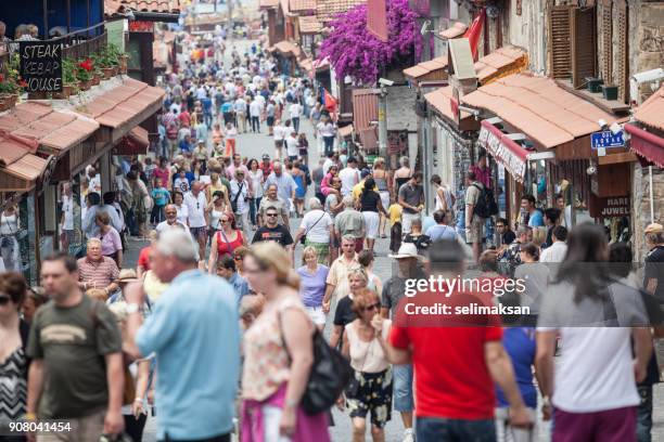 touristen, die zu fuß auf der hauptstraße in die stadt side antalya - tourism in antalya stock-fotos und bilder