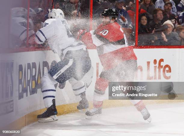 Gabriel Dumont of the Ottawa Senators body checks Roman Polak of the Toronto Maple Leafs into the end boards at Canadian Tire Centre on January 20,...