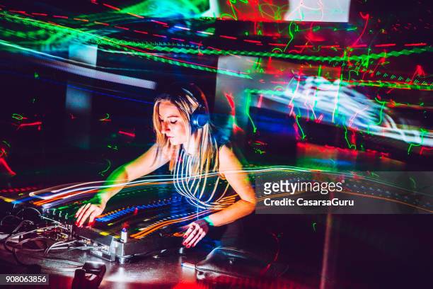 joven mujer dj mezclando música en una discoteca - dj de club fotografías e imágenes de stock