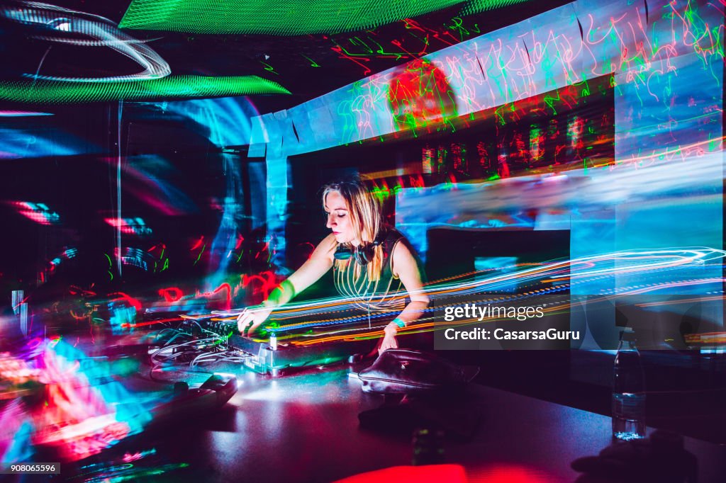 Junge weibliche DJ mischen von Musik in einem Nachtclub
