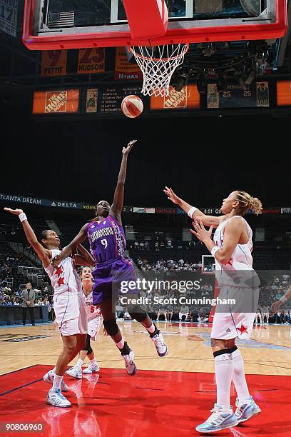 Hamchetou Maiga-Ba of the Sacramento Monarchs takes the ball to the basket against Iziane Castro Marques and Erika de Souza of the Atlanta Dream...