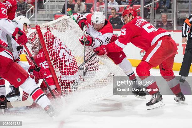 Jimmy Howard of the Detroit Red Wings defends the net while teammate Niklas Kronwall battles against Marcus Kruger of the Carolina Hurricanes during...