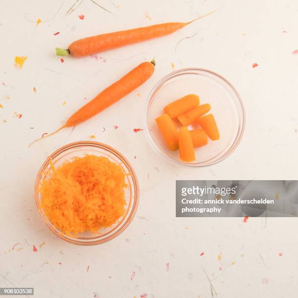 grated carrots, chopped carrots and two whole carrots. - carotine stock-fotos und bilder