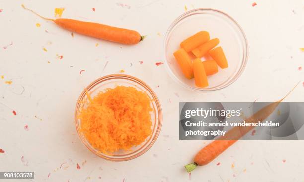 grated carrots, chopped carrots and two whole carrots. - carotine stock-fotos und bilder