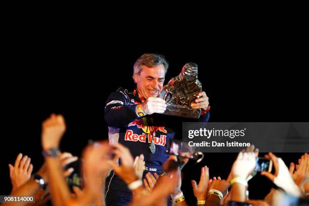 Carlos Sainz of Spain and Peugeot Total celebrates victory with their team on the podium after stage fourteen of the 2018 Dakar Rally, a loop stage...