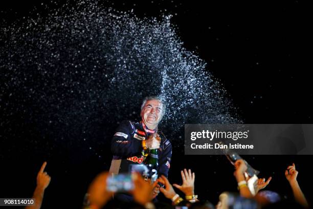 Carlos Sainz of Spain and Peugeot Total celebrates victory with their team on the podium after stage fourteen of the 2018 Dakar Rally, a loop stage...