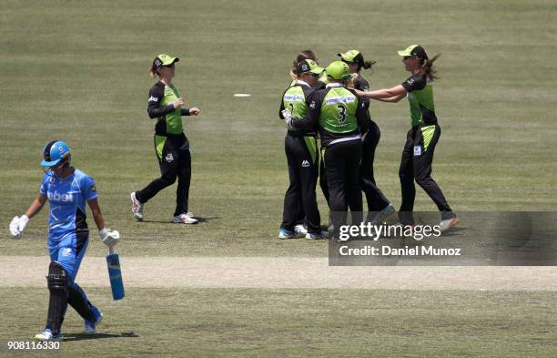 Thunder players celebrate after taking the wicket of Sophie Devine during the Women's Big Bash League match between the Adelaide Strikers and the...
