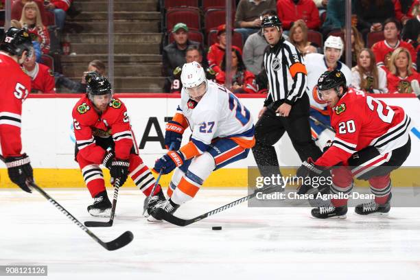 Anders Lee of the New York Islanders chases the puck against Duncan Keith and Brandon Saad of the Chicago Blackhawks in the third period at the...
