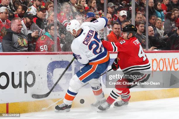 Jason Chimera of the New York Islanders and Gustav Forsling of the Chicago Blackhawks get physical chasing the puck in the third period at the United...