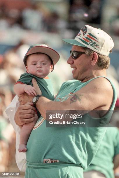 Young fan and an old fan watch the Miami Dolphins defeat the San Diego Chargers 12-9 at Joe Robbie Stadium, in Miami, FL.