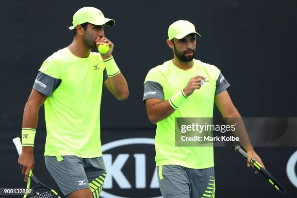 Juan Sebastian Cabal of Colombia and Robert Farah of Colombia talk tactics in their third round men's doubles match against Leander Paes of India and...