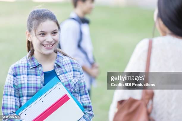 junior hoge student ontmoet nieuwe vriend op school - junior high student stockfoto's en -beelden