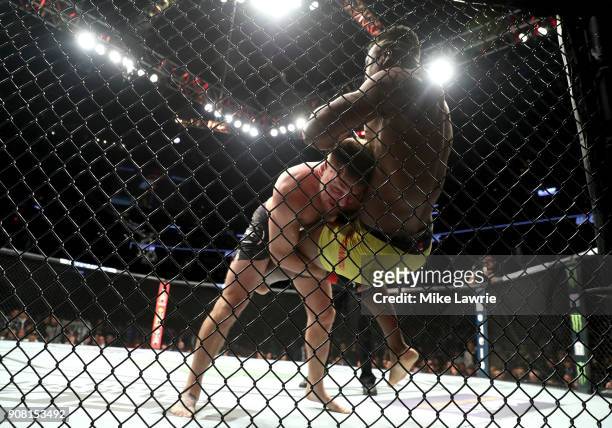 Stipe Miocic takes down Francis Ngannou in their Heavyweight Championship fight during UFC 220 at TD Garden on January 20, 2018 in Boston,...
