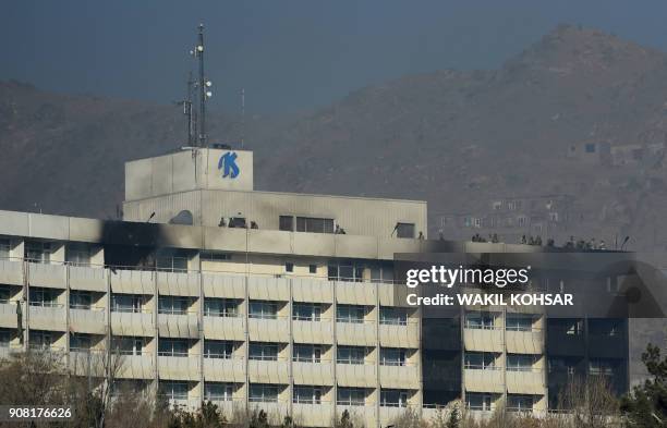 Afghan security personnel take position at the rooftop of the Intercontinental Hotel during a fight between gunmen and Afghan security forces in...