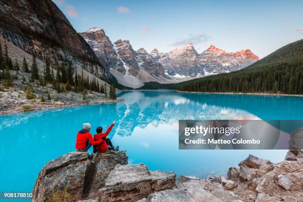 couple looking at moraine lake, banff, canada - canada lake stock pictures, royalty-free photos & images