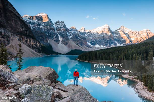 man at moraine lake at sunrise, banff, canada - kanada landschaft stock-fotos und bilder