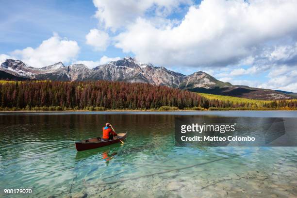 man canoeing on lake, jasper national park, canada - canada photos et images de collection
