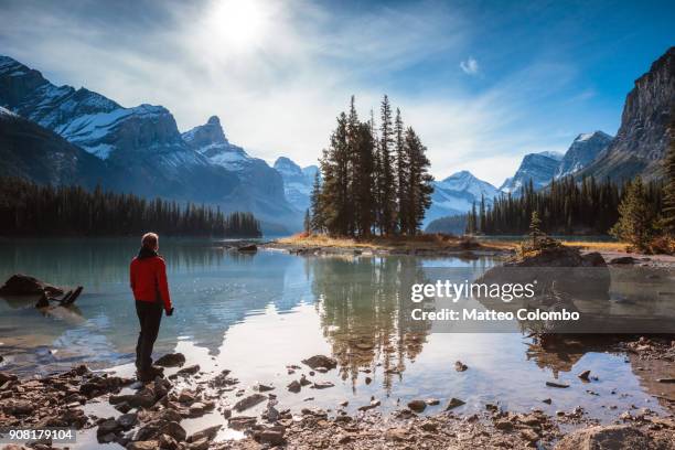 man looking at spirit island, maligne lake, canada - jasper stock pictures, royalty-free photos & images