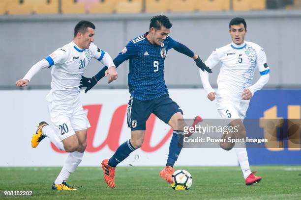 Kyosuke Tagawa of Japan fights for the ball with Dostonbek Tursunov of Uzbekistan and Abbosjon Otakhonov of Uzbekistan during the AFC U23...