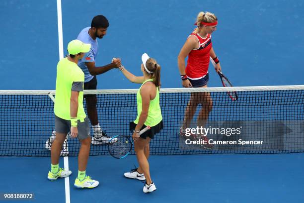 Timea Babos of Hungary and Rohan Bopanna of India are congratulated by Ellen Perez of Australia and Andrew Whittington of Australia after winning...