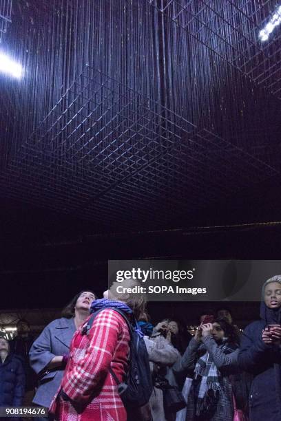 The crowd looking upwards and capturing the overhead light installations in King's Cross during Lumiere London.