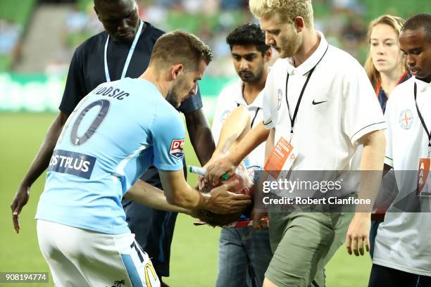 Dario Vidosic of the City consoles Nathaniel Atkinson as he is stretchered off with an injury during the round 17 A-League match between Melbourne...