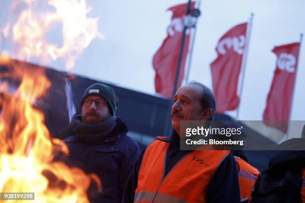 Members of public transport union Eisenbahn und Verkehrsgewerkschaft demonstrate near fire barrels in front of the convention center ahead of a...