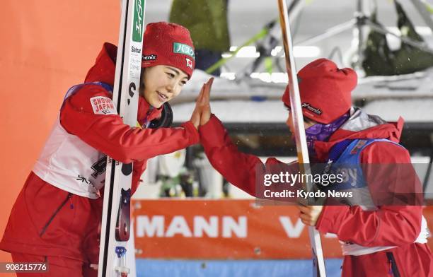 Japan's Sara Takanashi and Yuki Ito high-five at a women's World Cup ski jumping event in Yamagata on Jan. 21, 2018. Ito placed second in the event...