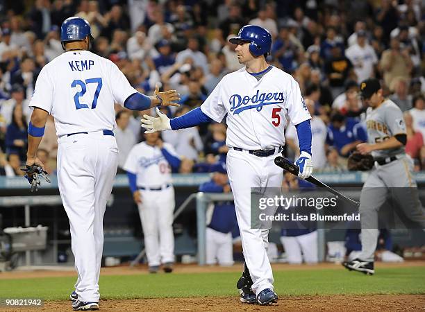 Matt Kemp is congratulated by teammate Mark Loretta of the Los Angeles Dodgers after scoring in the fifth inning against the Pittsburgh Pirates at...
