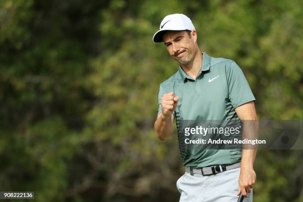 Ross Fisher of England reacts after holing a putt for bogie on the tenth green during the final round of the Abu Dhabi HSBC Golf Championship at Abu...