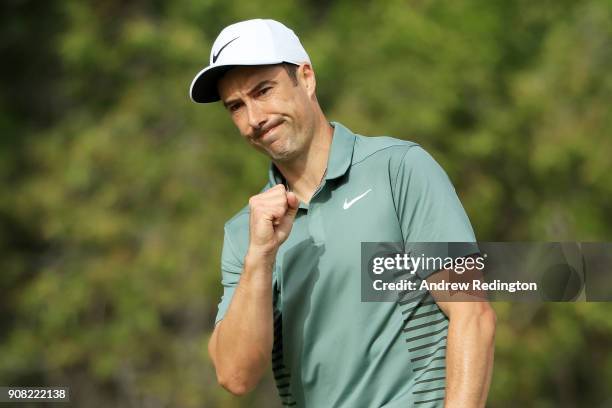 Ross Fisher of England reacts after holing a putt for bogie on the tenth green during the final round of the Abu Dhabi HSBC Golf Championship at Abu...