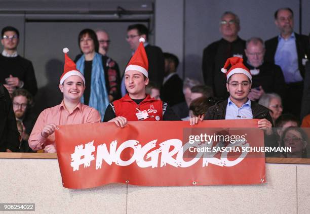 Opponents to a a new grand coalition unfold a banner reading "#NoGroKo" on January 21, 2018 in Bonn, western Germany, at the beginning of the Social...