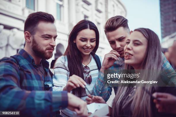 cute group of people eating donuts on fair in town square - donut man stock pictures, royalty-free photos & images