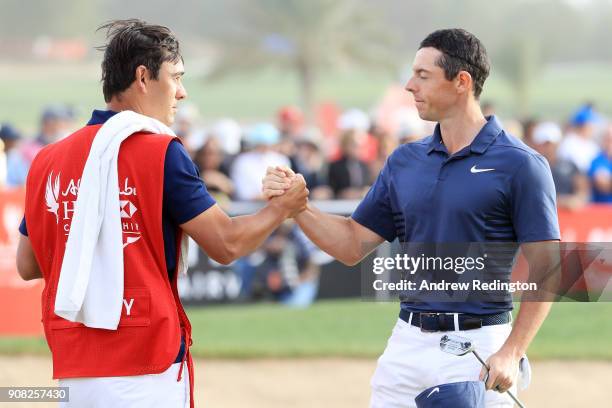 Rory McIlroy of Northern Ireland and caddie Harry Diamond shake hands after finishing on the 18th green during the final round of the Abu Dhabi HSBC...