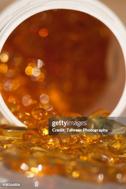 fish oil capsules spilled from jar - vitamin a stock pictures, royalty-free photos & images