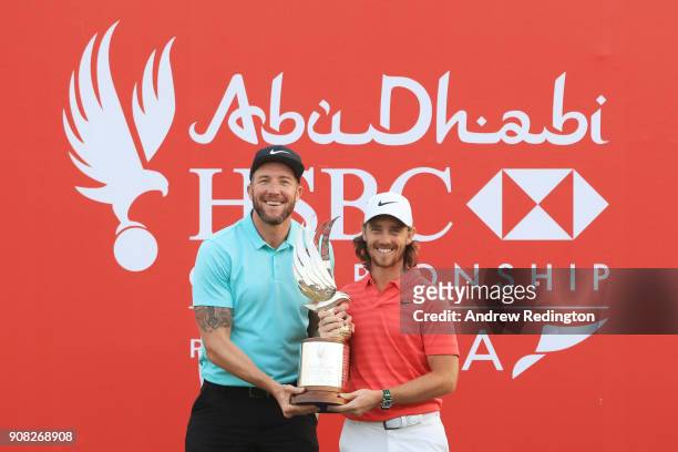 Tommy Fleetwood of England celebrates with the winner's trophy and caddie Ian Finnis after the final round of the Abu Dhabi HSBC Golf Championship at...