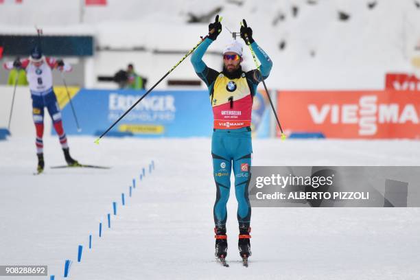 France's Martin Fourcade celebrates as he crosses the finish line to win the Men 15 km Mass Start Competition of the IBU World Cup Biathlon in...