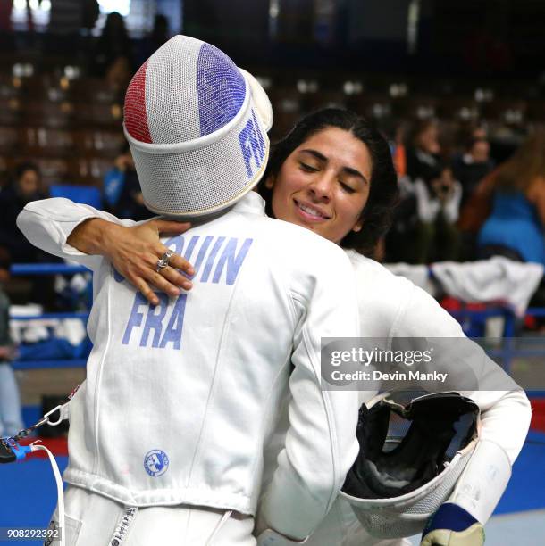 Josephine Jacques Andre Coquin of France hugs fellow competitor Natalie Vie of the USA after eliminating her from competition at the Women's Epee...