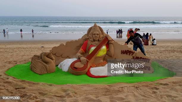 Visitors look near to the Goddess Saraswati's sand sculpture as it is creating by sand artist Manas Sahoo on the eve of Basanta Panchami or Saraswati...