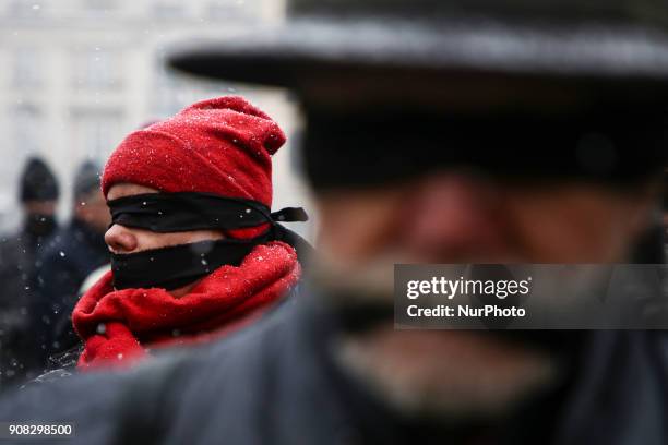 People wearing black bands on their eyes and mouth demonstrate in Stolen Justice silent protest at the Main Square in Krakow, Poland on 21 January,...