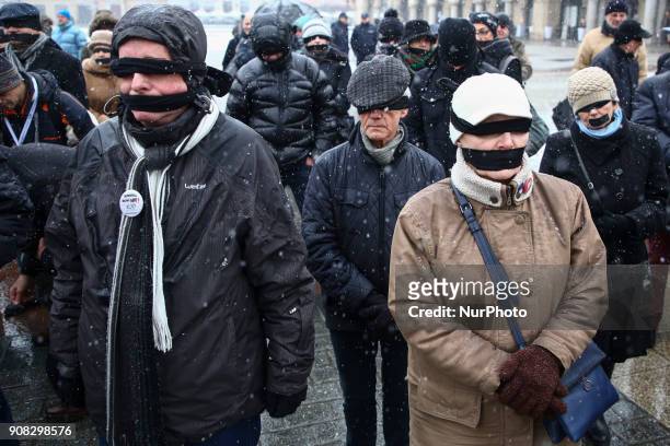 People wearing black bands on their eyes and mouth demonstrate in Stolen Justice silent protest at the Main Square in Krakow, Poland on 21 January,...