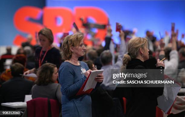 Helpers count the votes as delegates of Germany's social democratic SPD party hold up their voting cards during an extraordinary SPD party congress...