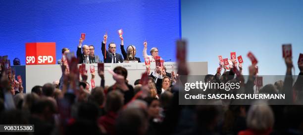 Delegates of Germany's social democratic SPD party hold up their voting cards during an extraordinary SPD party congress in Bonn, western Germany, on...